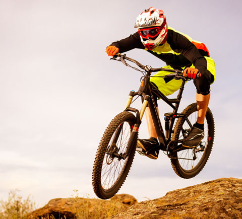 Mountain biker mid-jump on rocky trail