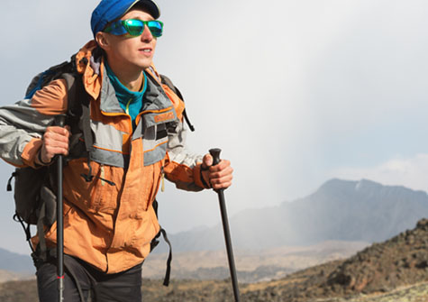 Hiker on alpine ridge wearing mirrored sunglasses
